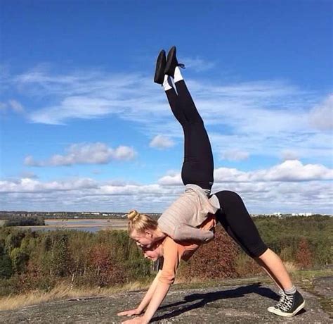 a woman doing a handstand on top of a rock