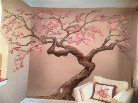 a living room with a tree painted on the wall