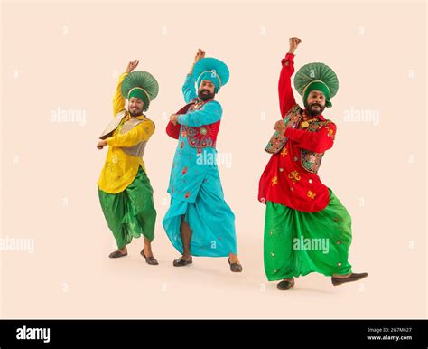 Three Bhangra dancers performing a dance step with hand gestures Stock Photo - Alamy