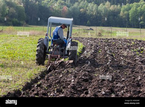 Farmer plowing with a tractor Stock Photo - Alamy