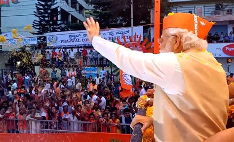 Prime Minister Narendra Modi waves at crowd during a roadshow