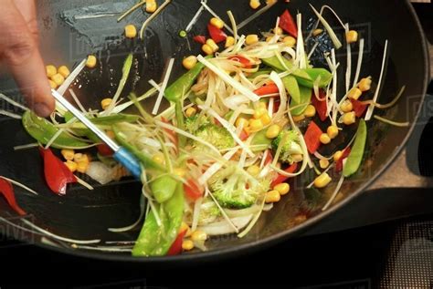 Sauteing vegetables in a wok - Stock Photo - Dissolve