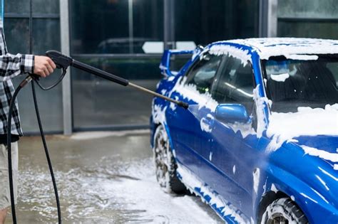 Premium Photo | Person washes foam from car body at car wash