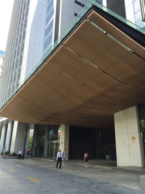 two people are walking in front of a building with a large awning over it