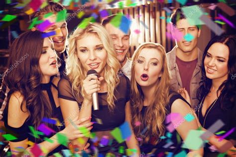 Happy friends singing karaoke together — Stock Photo © Wavebreakmedia #62504295