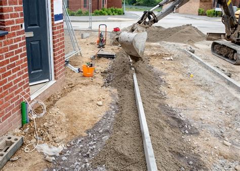 Premium Photo | Installation of edging kerb during footpath construction in front of new build ...