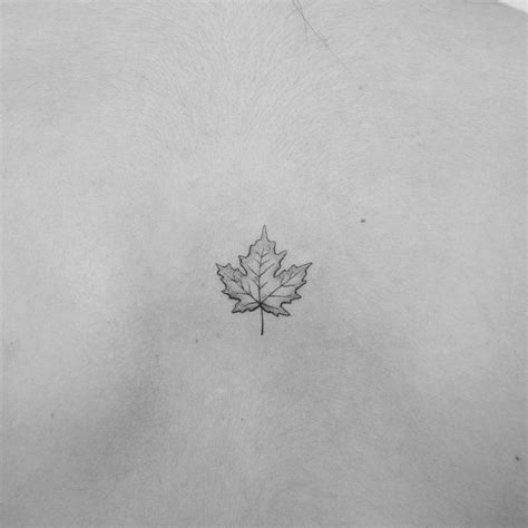 Small maple leaf tattoo located on the back.