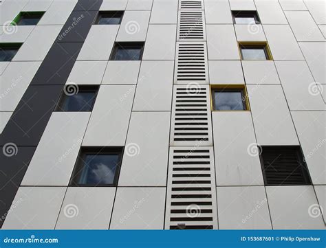 Silver Colored Metal Cladding Panels on a Modern Building with Repeating Windows and Geometric ...