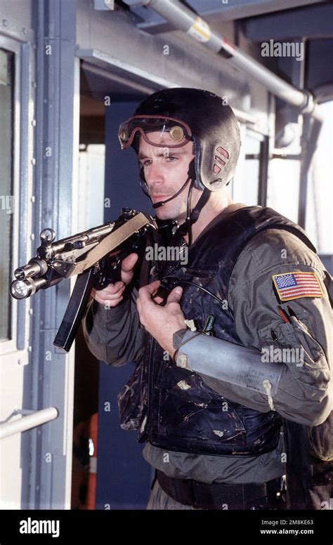 A U.S. Navy SEAL, armed with an MP5-N sub-machine gun, sets up a security perimeter on the upper ...