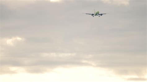 Super slow motion, long shot of an airplane approaching to land in a cloudy sky 13532598 Stock ...