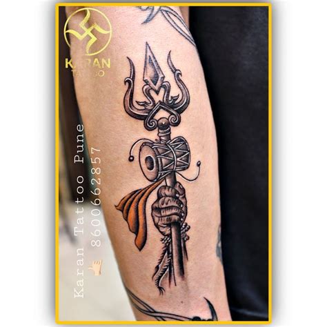 a person with a tattoo on their arm holding a knife and an arrow in his hand