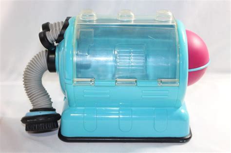 a blue toy vacuum with a red ball on it's side and a hose attached to the top