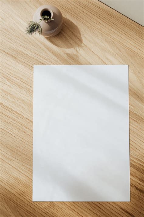 Blank white paper sheet on wooden table · Free Stock Photo