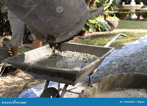 Workers Pouring Concrete from Mixer into Wheelbarrow Stock Photo ...