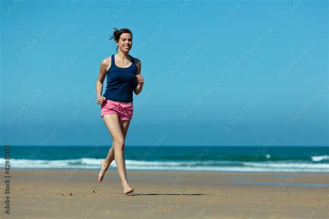 Girl running on the beach in barefoot Stock Photo | Adobe Stock