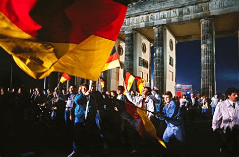 Celebrating the German reunification in Berlin. Waving the German flag at Berlin’s Brandenburg ...