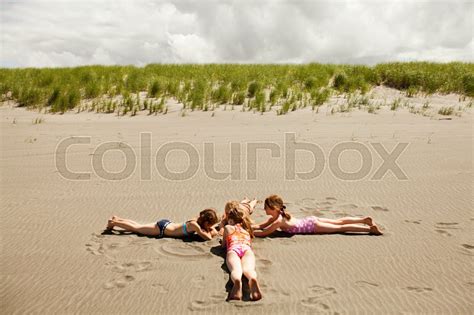 Girls lying on sand at beach | Stock image | Colourbox