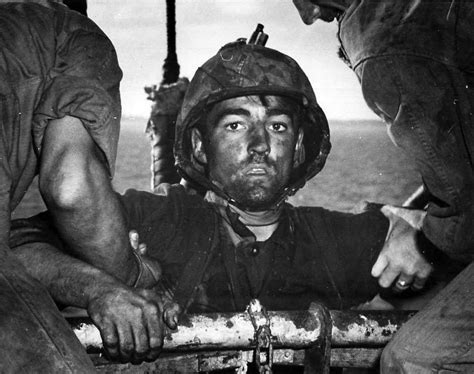 “The Thousand Yard Stare”—USMC Private Theodore J. Miller is helped aboard a ship after intense ...