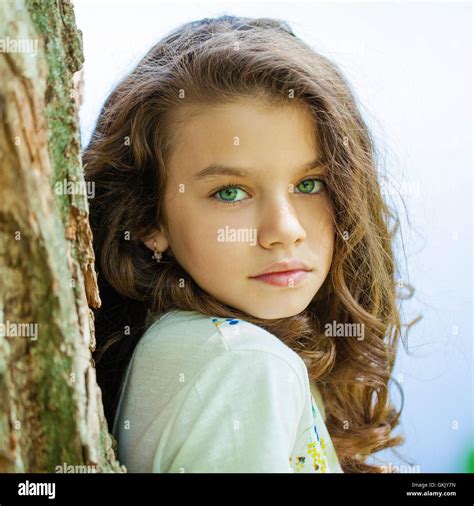 Portrait of a beautiful young little girl on the background of summer park Stock Photo - Alamy