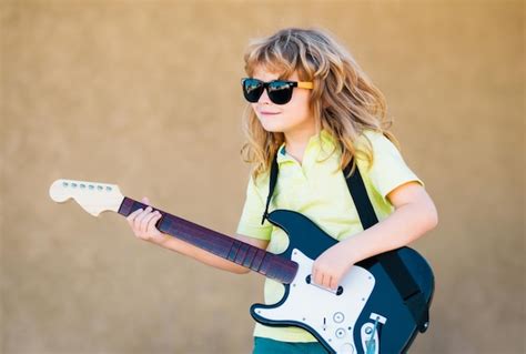 Premium Photo | Boy with guitar child plays a guitar and sings kids ...