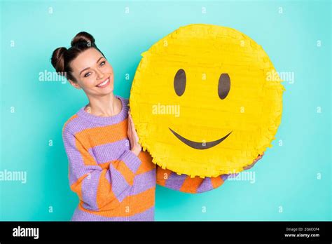 Portrait of satisfied young girl arms holding big paper emoji toothy ...