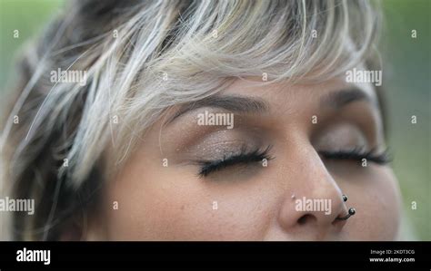 Person closing eyes in meditation. Woman opening eye to sky smiling Stock Photo - Alamy