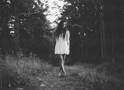 "A Beautiful Young Woman Walks Alone In A Dark Woods" by Stocksy Contributor "HOWL" - Stocksy