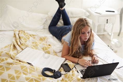 Teenage girl lying on bed working with laptop, high angle - stock photo 273931 | Crushpixel