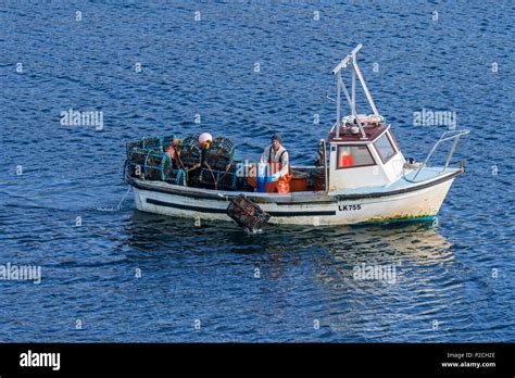 Fisherman in small fishing boat dropping / shooting lobster traps / lobster pots / lobster ...