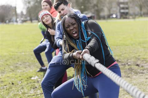 Determined team pulling rope in tug-of-war at park — dedication, effort - Stock Photo | #212282958