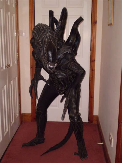 a man dressed as an alien standing in front of a door