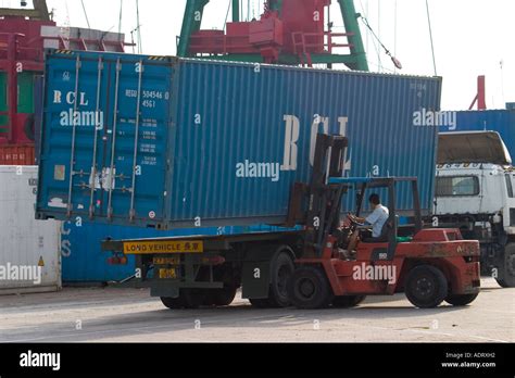 Forklift carries 40" foot shipping container loading onto transfer Stock Photo: 7705233 - Alamy