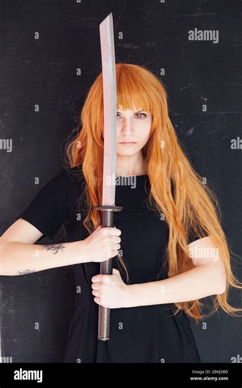 woman anime cosplayer with red hair Japanese sword Stock Photo - Alamy