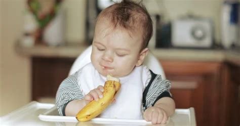 Baby boy eating a banana | Stock Video | Pond5