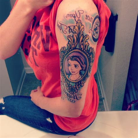 a woman with a tattoo on her arm sitting in front of a mirror and ...