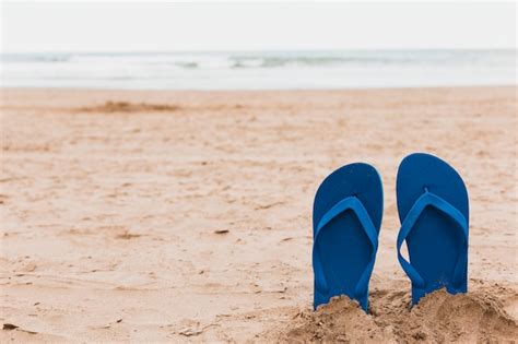 Free Photo | Beach concept with flip flops in sand