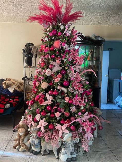 a christmas tree with pink flowers and decorations