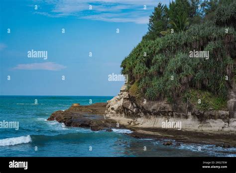 Pantai Klayar or Klayar Beach with rocks and strong waves against the blue sky. Motion blur ...