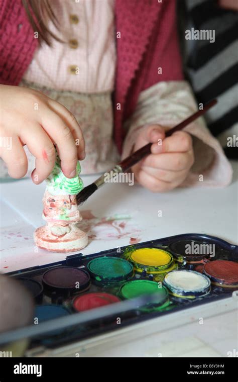 Child painting a plaster figurine Stock Photo - Alamy