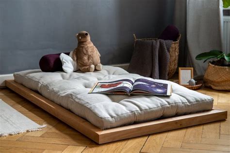 a dog sitting on top of a futon bed with a book open in front of it