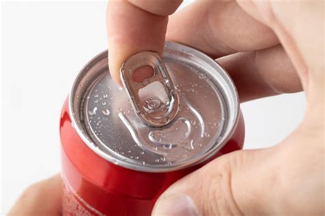 Premium Photo | Closeup of a man's hand opening a red can of soda on a white background a red ...