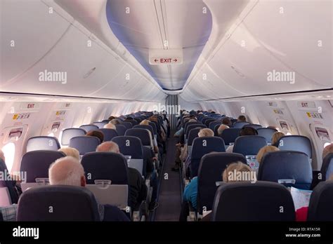 Interior of a plane with passengers on their seats Stock Photo - Alamy