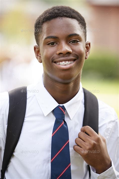 Portrait Of Male Teenage Student In Uniform Outside Buildings Stock Photo by monkeybusiness