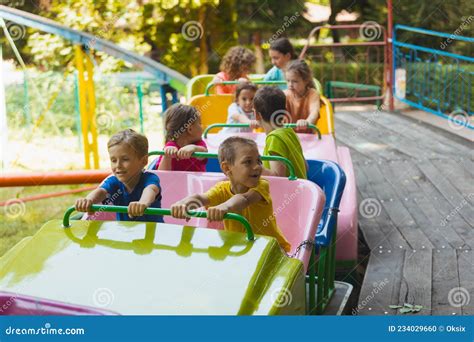 The Happy Kids on a Roller Coaster in the Amusement Park Stock Photo ...