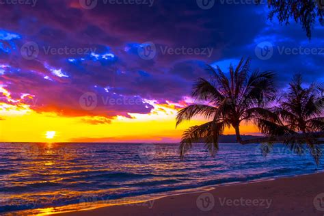 Beautiful sunset over the sea on tropical beach with palm tree and colorful sky for travel and ...