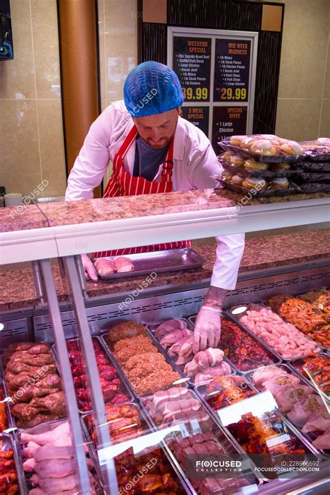 Butcher checking the meat display in butchers shop — fresh, Variety - Stock Photo | #228966692