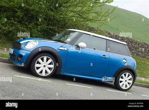 Blue mini cooper s car parked at the side of the road in a village in the English countryside ...