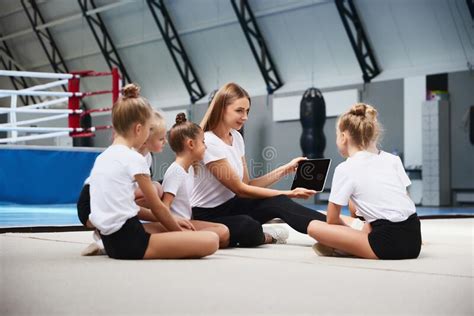 Coaching. Beginner Gymnastics Athletes Doing Exercises with Gymnastics Equipment at Sports Gym ...