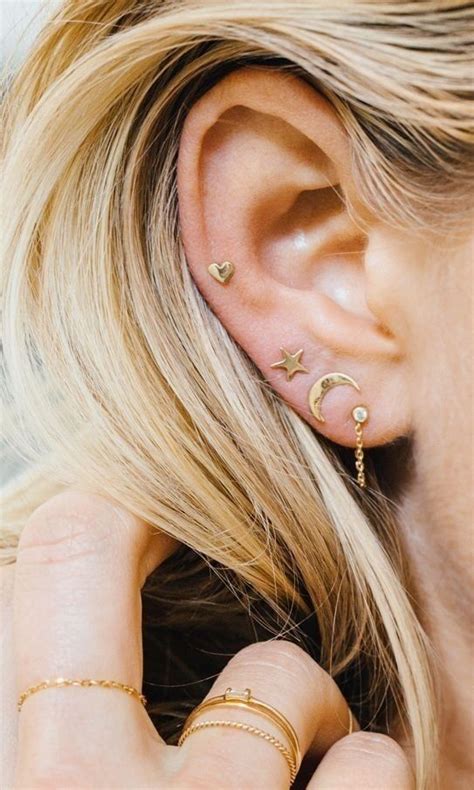 Picture Of stacked lobe piercings and a helix one with mix and match gold stud earrings