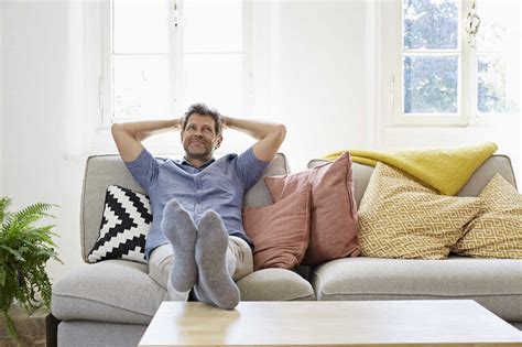 Man sitting on couch at home, relaxing stock photo